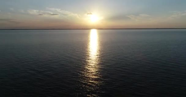 Scène de drone aérien volant au-dessus de l'eau vers le soleil au coucher du soleil, heure d'or. Réflexion, nuages colorés. Las Caas, Rio Negro, Uruguay — Video