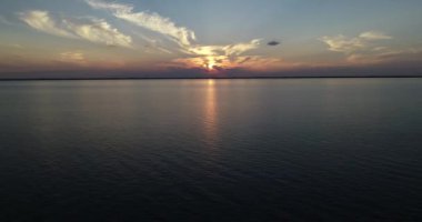Hava aracı günbatımında suyun üzerinde uçuyor, altın saat. Turuncu, sarı güneş ufukta. Uruguay nehri, Caas, Rio Negro.
