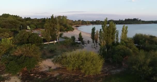 Scena z dronami powietrznymi na plaży przy naturalnym krajobrazie o zachodzie słońca. Ogólny panorama, latam wzdłuż plaża piasek i las przy rzeczka Urugwaj. Tło szerokiej rzeki. Las Caas, prowincja Rio Negro, Urugwaj — Wideo stockowe