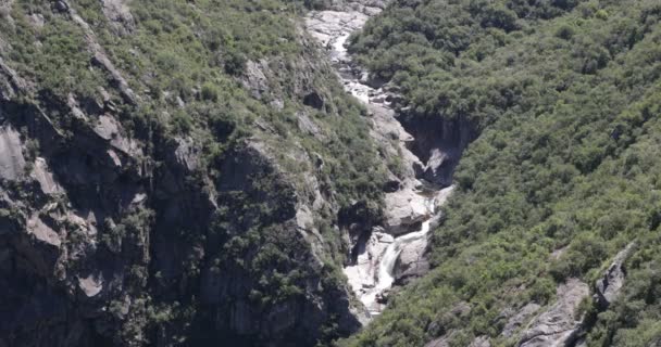 Río de montaña con cascadas y cascada en la antigua cuenca rocosa erosionada entre el paisaje leñoso. Parque Nacional Quebrada del Condorito, Córdoba, Argentina — Vídeo de stock