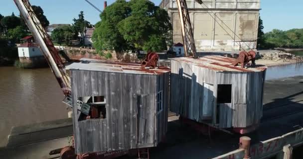 Luchtfoto drone scène vliegen over oude houten kranen detail van houten en ijzeren machines. Verlaten havenconstructies. Unesco, Fray Bentos, Uruguay — Stockvideo