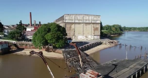 Escena aérea de drones de antiguos cobertizos abandonados en el puerto. Grúas, silos. Volando de grúas ascendiendo a vista general de construcciones . — Vídeos de Stock