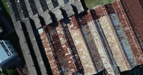 Aerial top view of old rusty sheds and new sheds. Detail of metal roof top. Ascending to general view of construction. Unesco, The Anglo, Fray Bentos, Uruguay — Stockvideo
