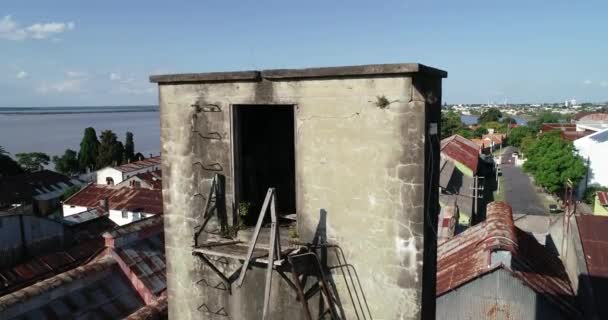 Cena de drone aéreo de torre de tanque de água quebrada descobrindo galpões industriais enferrujados e cidade de Fray Bentos no fundo. Anglo, Unesco, Fray Bentos, Uruguai — Vídeo de Stock