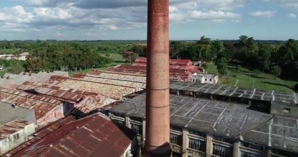 Aerial dron szczegół pomarańczowy cegła rura wieża opuszczony przemysłowy budownictwo. Lecąc bardzo blisko i powyżej rury. Tył zardzewiałych szopów. Unesco, Fray Bentos, Urugwaj — Wideo stockowe