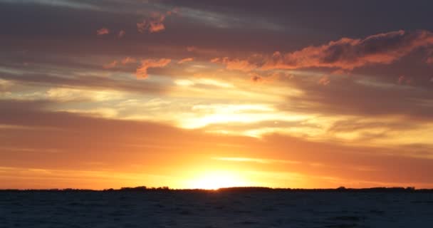 Escena naranja al atardecer, paisaje marino a la hora dorada. Movimiento del agua y horizonte colorido con nubes y sol. Uruguay, Fray bentos, Las Canas — Vídeo de stock