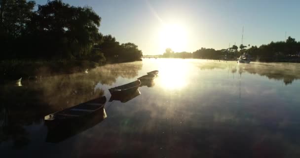 Escena del amanecer en Riverbend. Niebla dorada, vapor, moviéndose en la superficie del río volando muy cerca de los barcos. Volumen de luz. Mercedes, rio Negro, Uruguay — Vídeo de stock