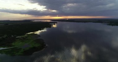 Hava aracının günbatımında doğal acımasız nehir manzarası. Rio Negro Nehir Ağzı 'ndan Uruguay Nehri' ne ve ufukta turuncu renkler görünüyor. Soriano, Uruguay