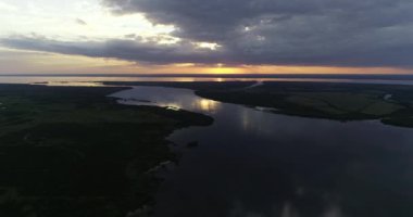 Hava aracının günbatımında doğal acımasız nehir manzarası. Rio Negro Nehir Ağzı 'ndan Uruguay Nehri' ne ve ufukta turuncu renkler görünüyor. Soriano, Uruguay
