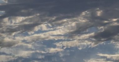 Sakin su yüzeyine yansıyan bulutları kapatın. Nehrin dalgalanma hareketleri yüzünden gökyüzü görüntüsünün bozulması. Doğa dokuları.