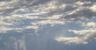 Sakin su yüzeyine yansıyan bulutları kapatın. Nehrin dalgalanma hareketleri yüzünden gökyüzü görüntüsünün bozulması. Doğa dokuları.