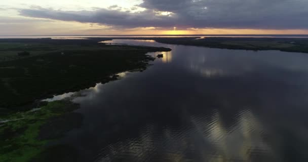 Letecká bezpilotní scéna s obecným pohledem na přirozenou řeku Meandric při západu slunce. Pozadí ústí řeky Rio Negro do Uruguaye a oranžové barvy na obzoru. Soriano, Uruguay — Stock video