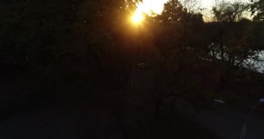 Hava sahnesi ağaç brançlarının yanında uçuyor ve günbatımını bitki örtüsü arasında bırakıyor. Nehir ve ufukta güneş olan vahşi bir manzara keşfediyor. San Salvador nehri, Dolores şehri, Soriano, Uruguay