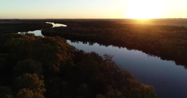 Letecká scéna s vysokým panoramatickým výhledem na klidnou řeku při západu slunce. Přírodní prostředí, řeka Meandric. Odraz oranžové oblohy na vodní hladině. Řeka San Salvador, Dolores, Uruguay — Stock video