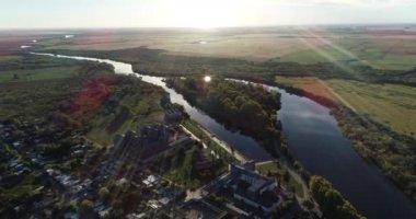 Kırsal kesimde hava panoramik manzarası ve günbatımında acımasız doğal nehir. Nehir, tarlalar ve arka planda güneş. San Salvador nehri, Dolores şehri, Uruguay