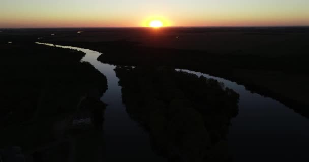 Flygfoto panorama scen av naturligt landskap vid solnedgången. Silhuett av skog och flod. Sol vid horisonten. Vacker kväll i San Salvador floden, Dolores stad, Soriano, Uruguay — Stockvideo