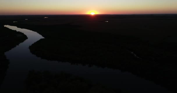 Scena aerea panoramica di paesaggio naturale al tramonto. Silhouette di boschi e fiumi. Sole all'orizzonte. Bella serata del fiume San Salvador, città Dolores, Soriano, Uruguay — Video Stock