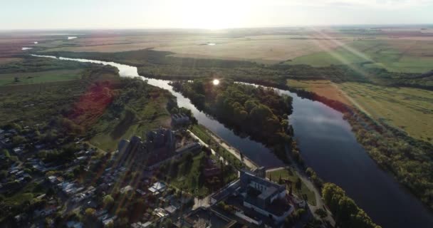 Escena panorámica aérea de pueblo rural y río natural meandrico al atardecer. Río, tierras de cultivo y sol al fondo. Río San Salvador, ciudad de Dolores, Uruguay — Vídeo de stock