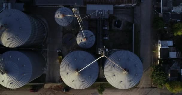 Scène aérienne supérieure du groupe de silos pour le stockage des semences agricoles. Voler au-dessus et le long de la construction métallique. Dolores, Soriano, Uruguay — Video