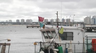 Balıkçı teknesinin kaptanlarının kokpitini kapatın. Bulutlu, rüzgarlı bir gün ve şehir manzarası. Punta del este limanı, Maldonado, Uruguay