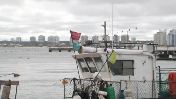 Balıkçı teknesinin kaptanlarının kokpitini kapatın. Bulutlu, rüzgarlı bir gün ve şehir manzarası. Punta del este limanı, Maldonado, Uruguay — Stok video