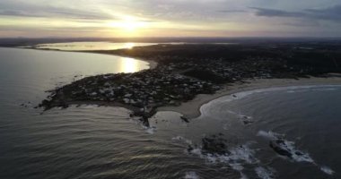 Günbatımında kumlu kıyıları ve deniz feneri olan Pensinsula 'daki turistik kasaba havası. Doğal manzaranın panoramik görüntüsüyle yükseklere uçuyor. Arka planda Jose Ignacio gölü var. Uruguay, Maldonado