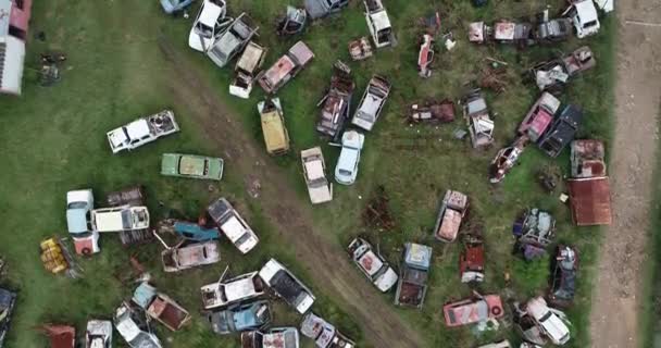 Aerial top scene of junkyard, close up of broken, destroyed, abandoned tires and cars. Panning across scarbyard. Pollution, environmental crisis. Piriapolis, Uruguay — Stock Video