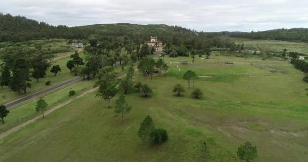 Aereo di castello medievale e giardini. Volando da vista generale di parco a vista superiore di costruzione storica. Boschi e montagne sullo sfondo. Castello di Piria, Piriapolis, Uruguay. — Video Stock