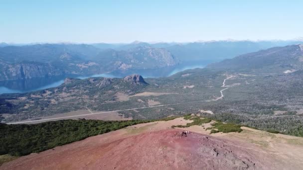 Flygfoto scen med panoramautsikt över Lacar sjön och andes bergskedja, upptäcka röd bergstopp med människor. Trekking vid Cerro Colorado, vulkan. San Martin de los Andes, neuquen — Stockvideo