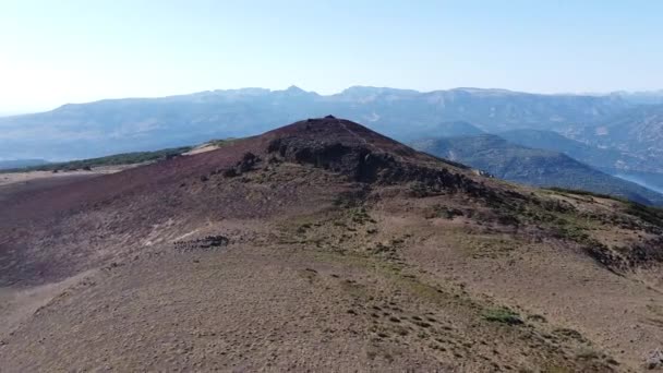 Volando hacia la cima de la montaña volcánica roja. Lago y cordillera de los Andes al fondo. Punto turístico de Cerro Colorado. San Martín de los Andes, Neuquén, Argentina — Vídeos de Stock