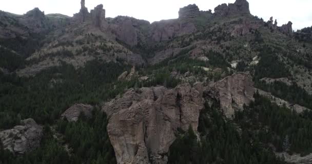 Escena aérea de drones de paisaje montañoso rocoso salvaje. Volando hacia acantilados con bosques. Punto de escalada Valle Encantado. Vista panorámica del paisaje natural. BARILOCHE — Vídeo de stock