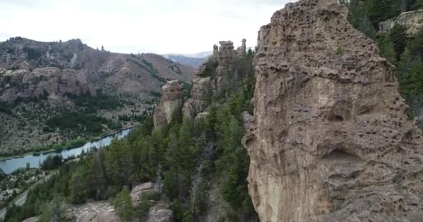 Scena lotnicza w górzystym krajobrazie lecącym między klifami. Przechodzi obok skalistych budowli. Odkrywanie, góry, lasy i czysta rzeka w tle. Valle Encantado, Bariloche. Argentyna — Wideo stockowe