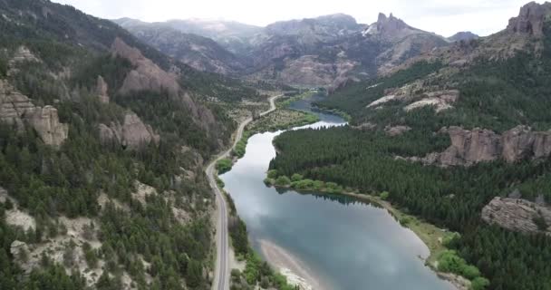 Luchtfoto drone scène vliegen boven zuiver blauwe rivier op bergachtig landschap. Rotsachtige kliffen en dennenbossen op berghellingen. Alumine rivier. Prachtige vallei van Valle Encantado, Bariloche, Rio negro. — Stockvideo