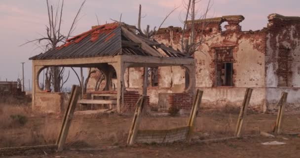 瓦礫の中の廃墟に沿って喘ぐ放棄された家。破壊された建造物、夜明けに街を歩く。日の出だ。ブエノスアイレス,アルゼンチン — ストック動画