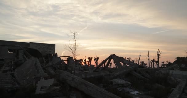 Прогулка по разрушенному заброшенному городу на рассвете. Восход солнца на заднем плане, силуэты деревьев и зданий. Город Эпекуэнов. Озил, Аргентина — стоковое видео