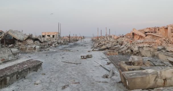 Walking through destructed abandoned city at dawn. Traveling along street between constructions rubble of Epecuen town. Lagoon at background. Buenos Aires, Argentina — Stock Video