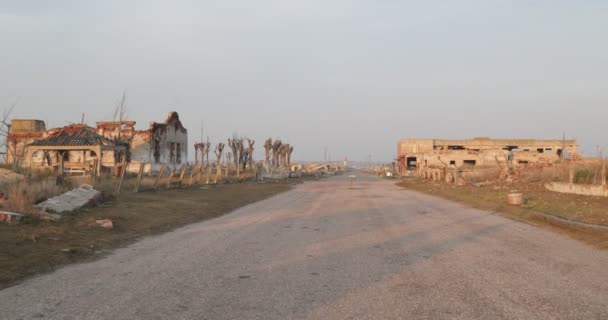 Walking through destructed abandoned city at dawn. Traveling along street between constructions rubble of Epecuen town. Lagoon at background. Buenos Aires, Argentina — Stock Video