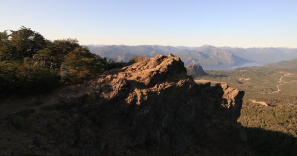 A fiatalember elérte a hegycsúcsot, felfedezte a tavi tavak széles táját, a nincstelen erdőket és az andes hegyláncokat. Lanin Nemzeti Park. Patagónia, Argentína. San Martin de los Andes megye — Stock videók