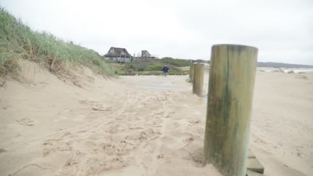 Långsam rörelse scen av barn promenader längs träväg på stranden. San Dunes i bakgrunden. Jose Ignacio, Rocha, Uruguay — Stockvideo