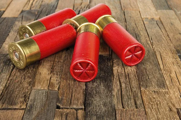 Cartucce da caccia rosse calibro 12 per fucile su fondo di legno . — Foto Stock