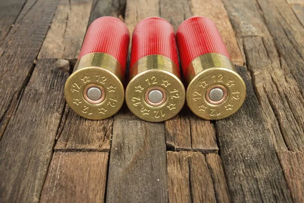 Cartuchos de caza rojos calibre 12 para escopeta sobre fondo de madera . — Foto de Stock