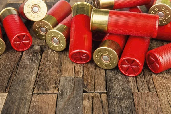Cartuchos de caza rojos calibre 12 para escopeta sobre fondo de madera . — Foto de Stock