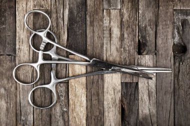 Cerrahi alet. Paslanmaz çelik forseps ahşap arka plan üzerinde.