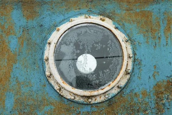 Patrijspoort op de blauwe muur van het oude schip. — Stockfoto