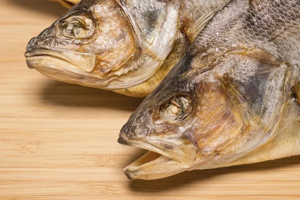Salty dry river fish to beer on a wooden table. — Stock Image Salty dry river fish to beer on a wooden table. Stock Picture