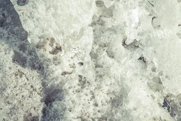 Spring background. Melting ice on beach on a sunny spring day. — Stock Photo, Image