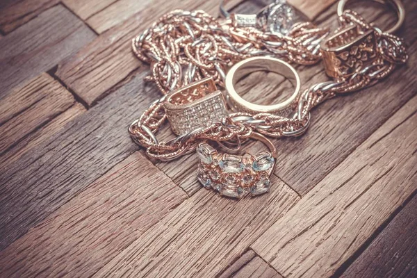 Mooie gouden sieraden op houten achtergrond. — Stockfoto