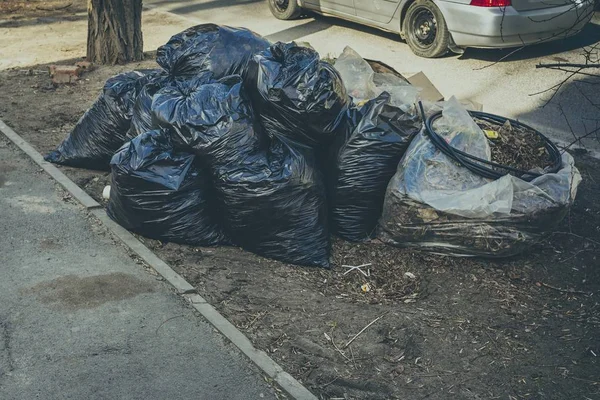 Pilha de sacos de lixo preto na calçada . — Fotografia de Stock