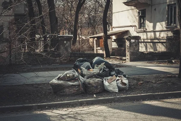 Pile of black garbage bags on sidewalk. — Stock Photo, Image