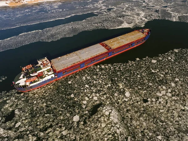 Cargo ship on the ice river in winter.